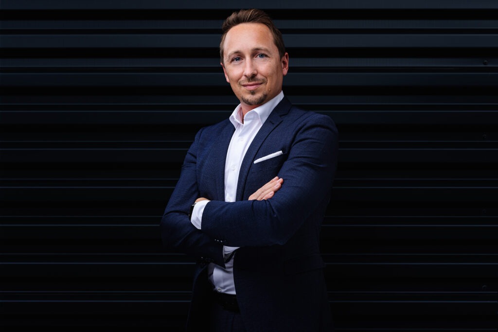 Ausdrucksstarkes Porträt eines Mitarbeiters vor einem dunklen Hintergrund in Ulm.