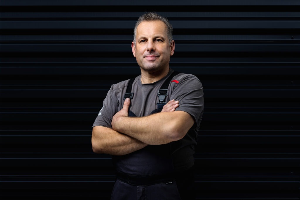 Ausdrucksstarkes Porträt eines Mitarbeiters vor einem dunklen Hintergrund in Ulm.