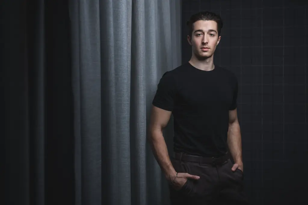 Ausdrucksstarkes Porträt eines jungen Unternehmers vor einem dunklen Hintergrund in Ulm.