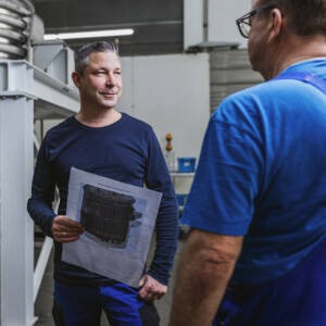 Zwei Männer diskutieren Details einer technischen Zeichnung in Wangen im Allgäu.