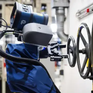 Nahaufnahme eines Roboterarms bei der präzisen Bedienung eines Ventils in einer Industrieanlage – Industriefotografie aus Ulm.