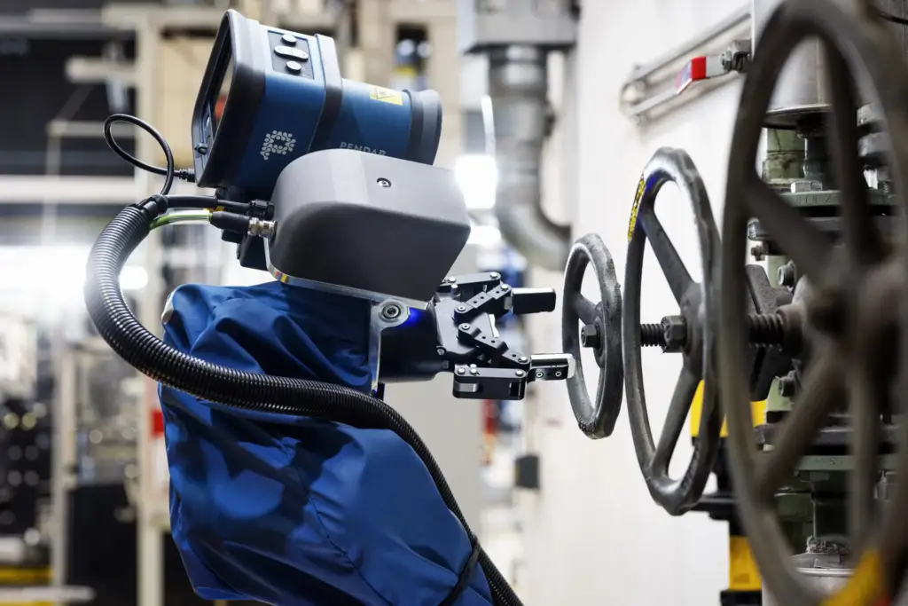 Nahaufnahme des Greifarms des Magirus Wolf R1 Löschroboters, der gerade ein metallisches Handrad an einer Industriearmatur greift – technische Industriefotografie aus Ulm.