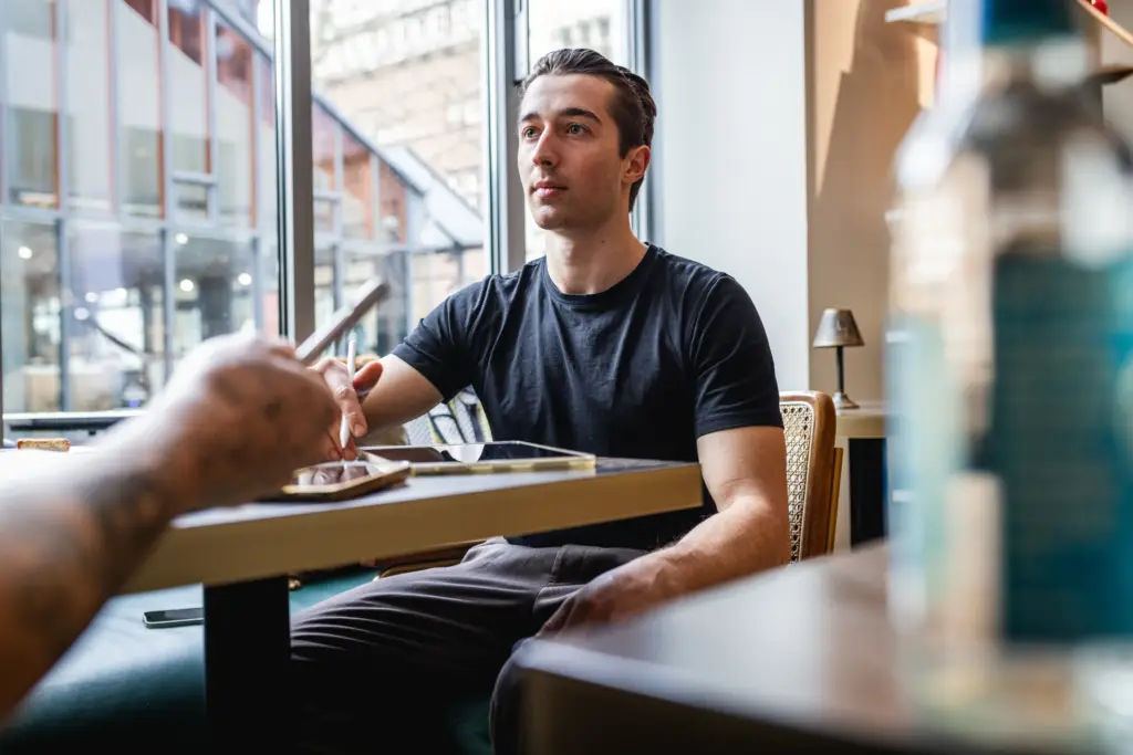 Ein junger Mann im Gespräch während eines Business-Meetings in einer modernen Ulmer Arbeitsumgebung.