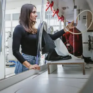 Eine junge Frau bei der Arbeit an einem Laborabzug mit Handschuhbox – technische Dokumentation und Wissenschaftsfotografie aus Ulm.